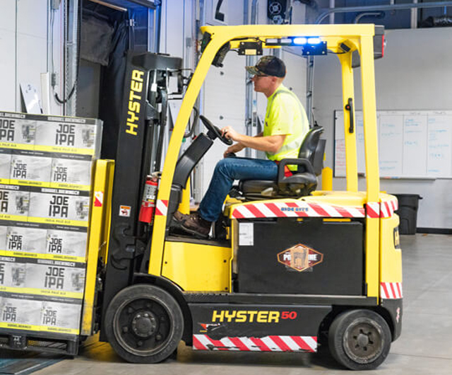 Forklift moving pallets inside warehouse facility