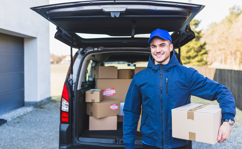 Smiling delivery man carrying a parcel